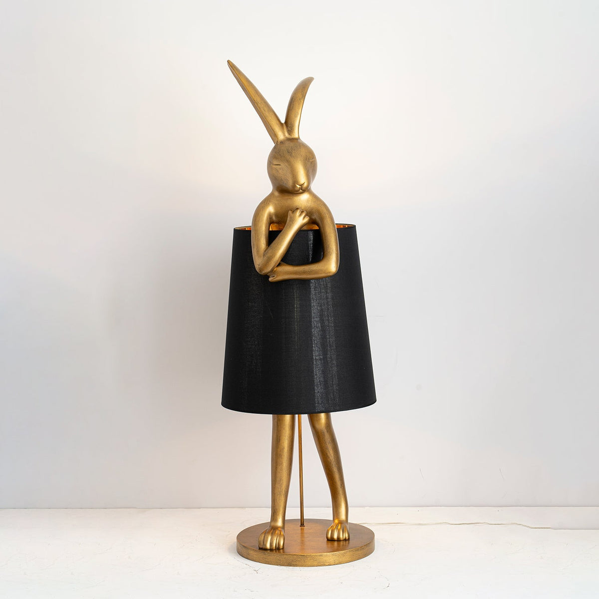 Lámpara de pie escultura de liebre Rabela – en oro envejecido con pantalla negra