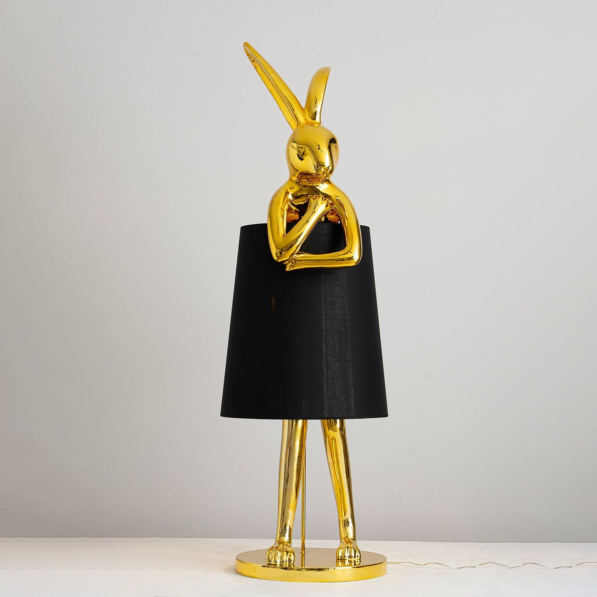 Lámpara de pie escultura de liebre Rabela – en dorado brillante con pantalla negra