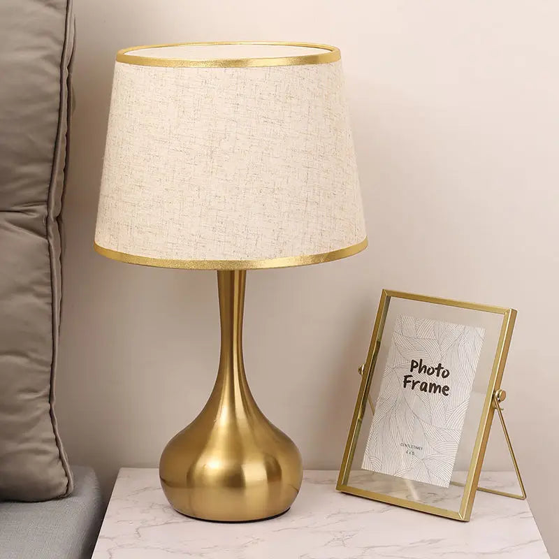 Lámpara de mesa con base dorada Orvala en un dormitorio acogedor – imagen 6