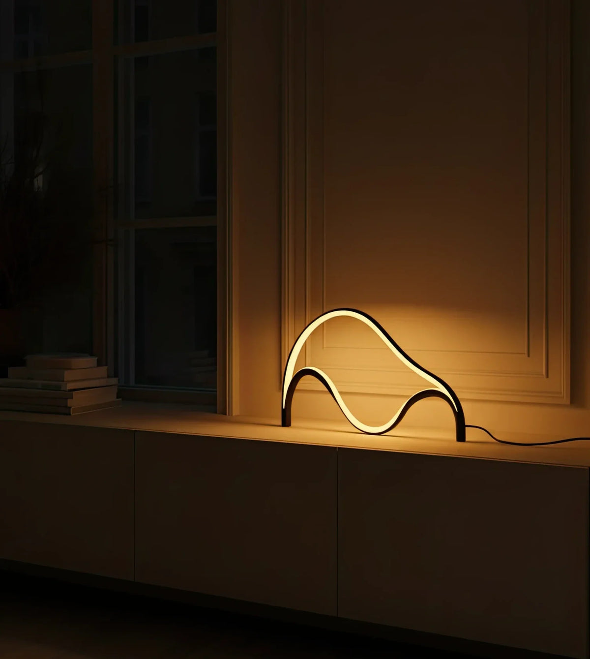 Lámpara de mesa LED escultural Mondea sobre un aparador blanco – imagen 4