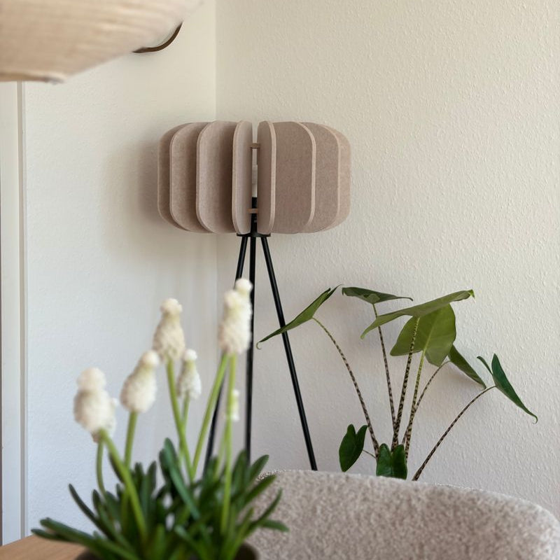 Lámpara de pie Yumara con pantalla de fieltro – en beige junto a una planta