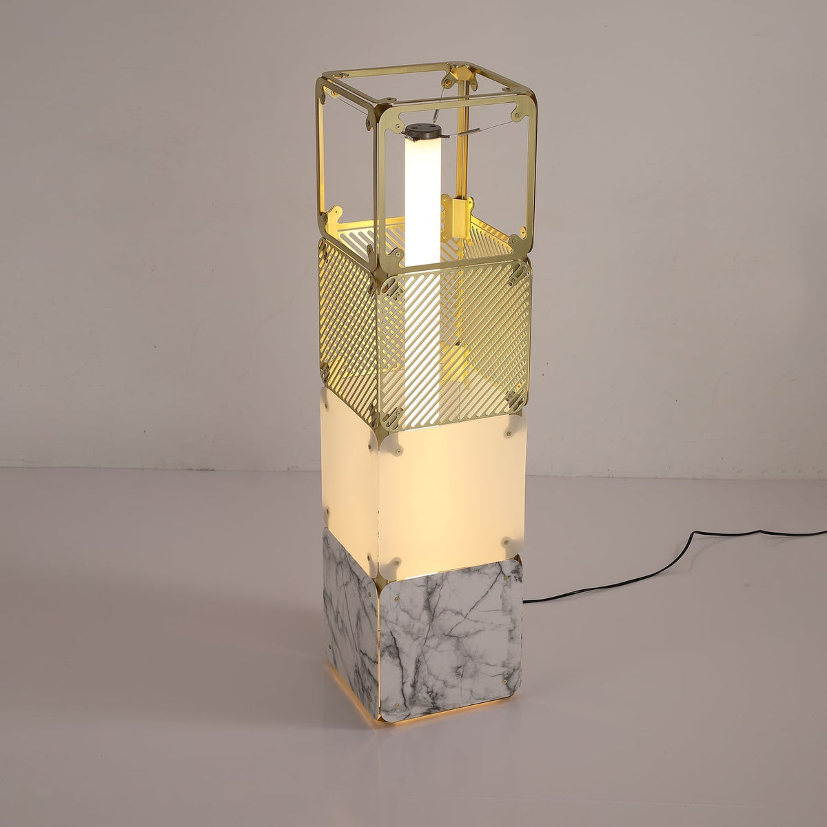 Lámpara de pie modular LED con cubos dorados y difusor blanco Sorina – de 91 cm encendida en una estancia