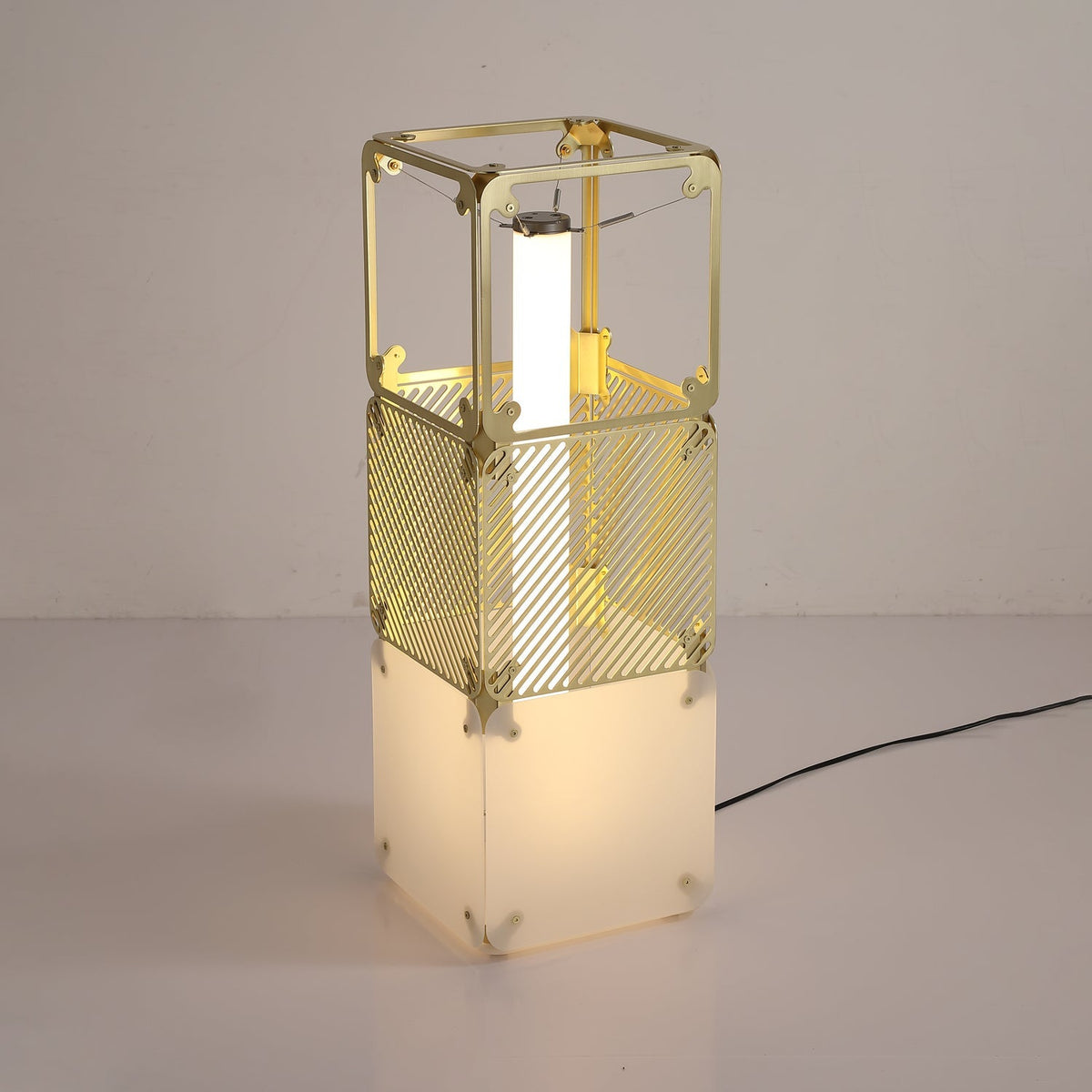 Lámpara de pie modular LED con cubos dorados y difusor blanco Sorina – en una estancia con luz cálida