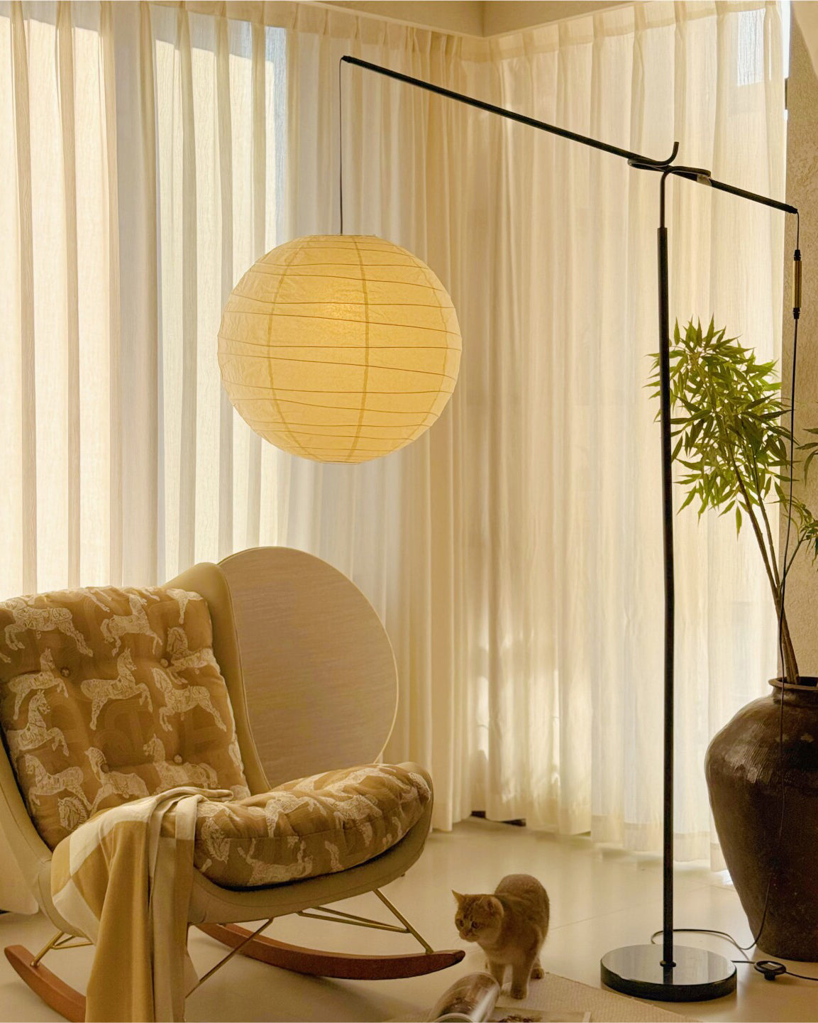 Lámpara de pie con farol de papel Clarinda junto a un sillón en el salón – imagen 10