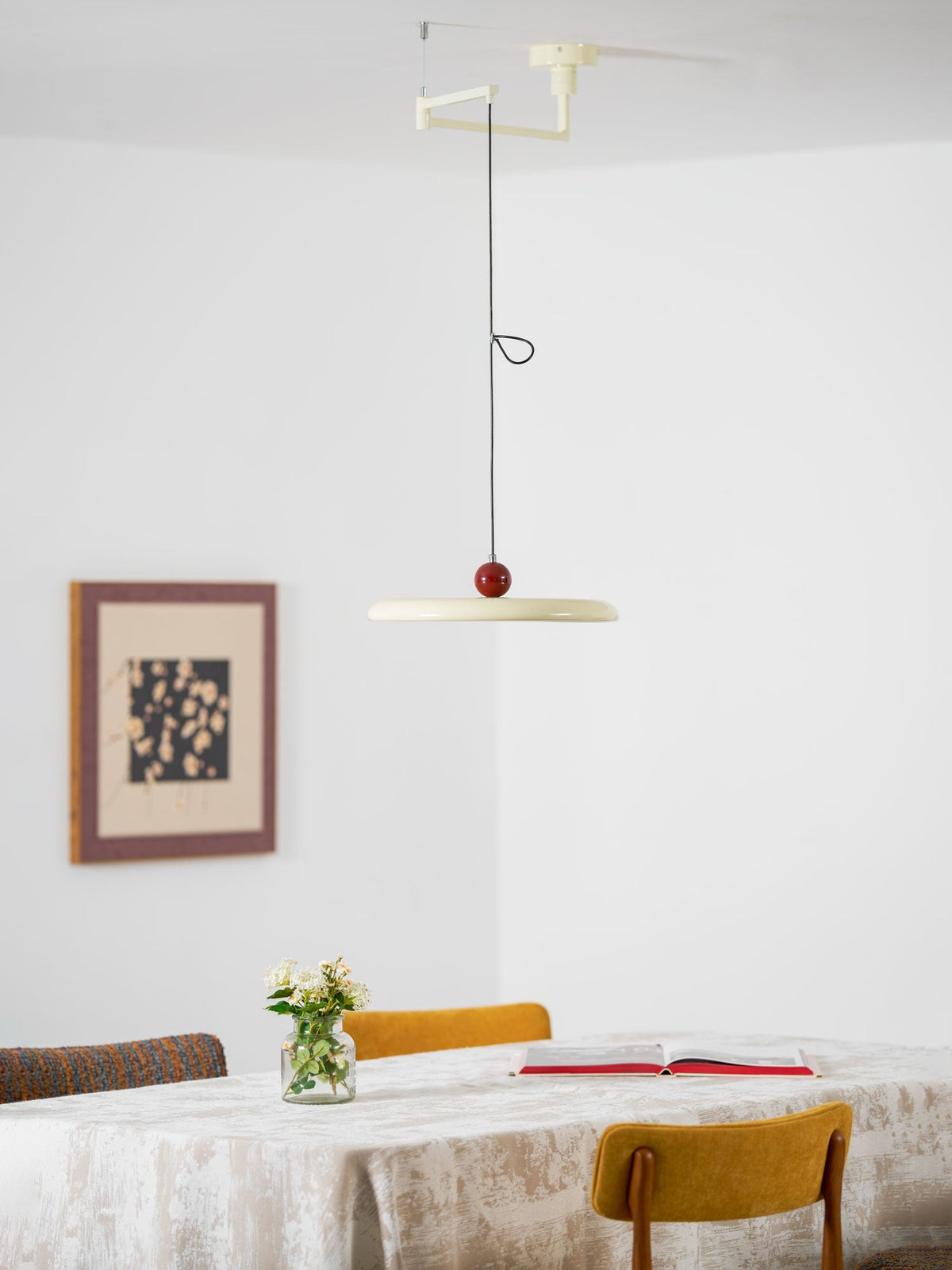 Lámpara colgante con brazo articulado Basela sobre una mesa de comedor – imagen 17