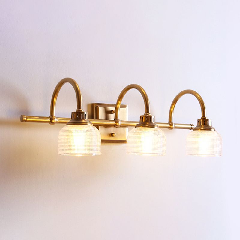 Aplique de pared Yarela con cristal estriado y latón – versión de 3 luces encendida