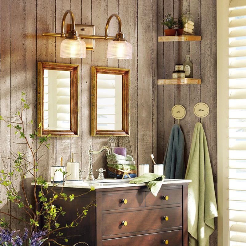 Aplique de pared Yarela con cristal estriado y latón – versión de 2 luces en un baño rústico