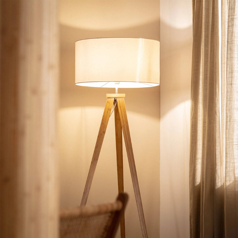 Lámpara de pie trípode de madera Talvia – encendida junto a la ventana