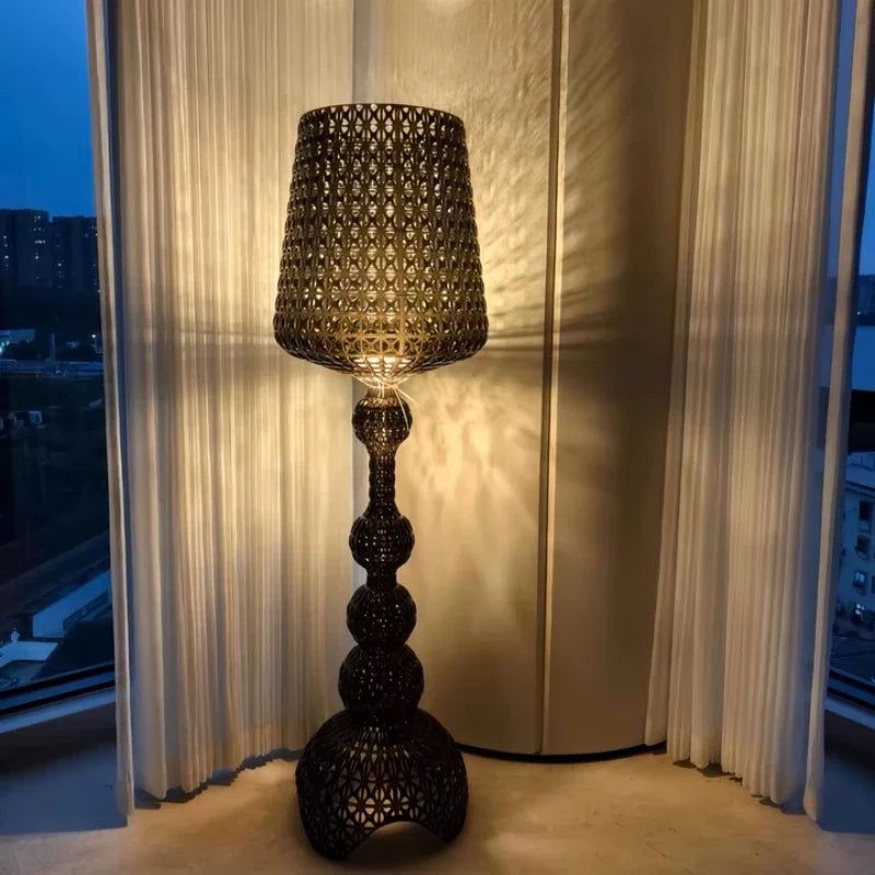 Lámpara de pie calada Tracela – negra junto a la ventana