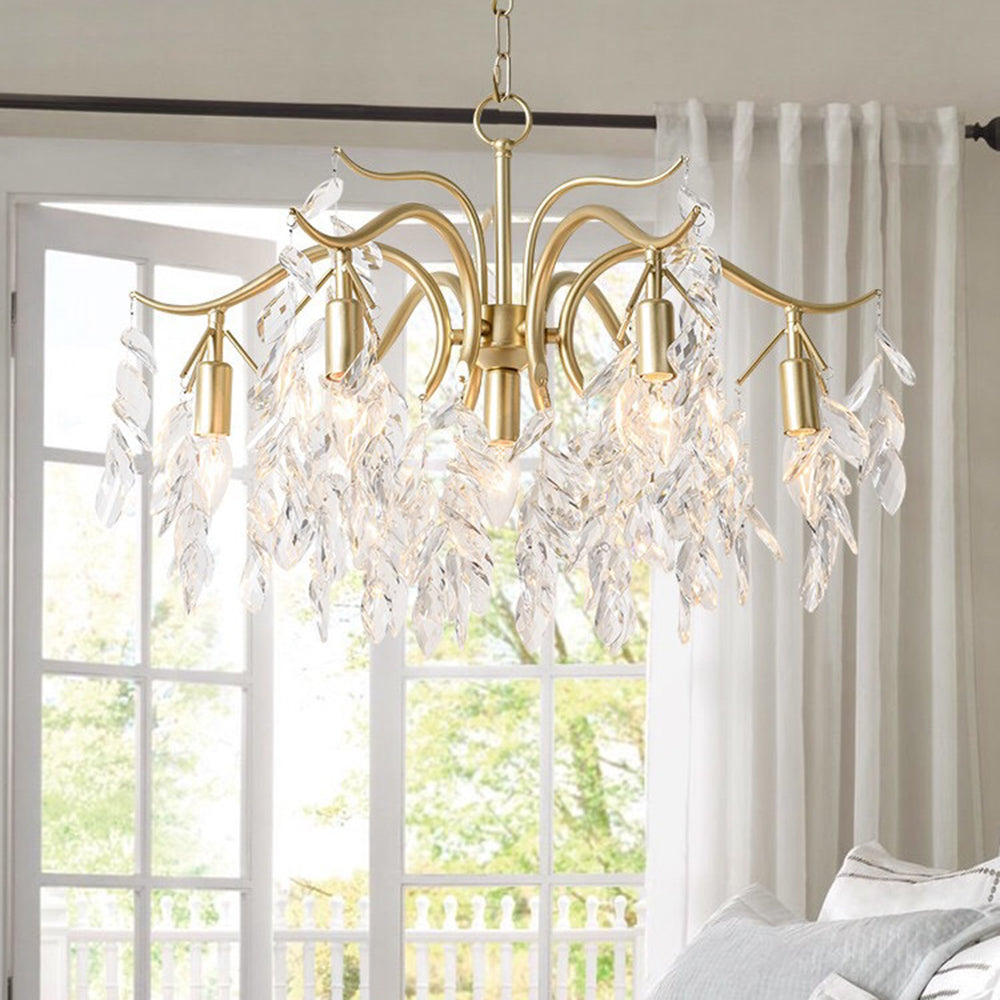 Lámpara de araña de ramas con hojas de cristal Frondina – dorada de 7 luces junto a una ventana