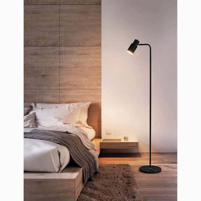 Lámpara de pie de lectura Quilia – en negro junto a la cama