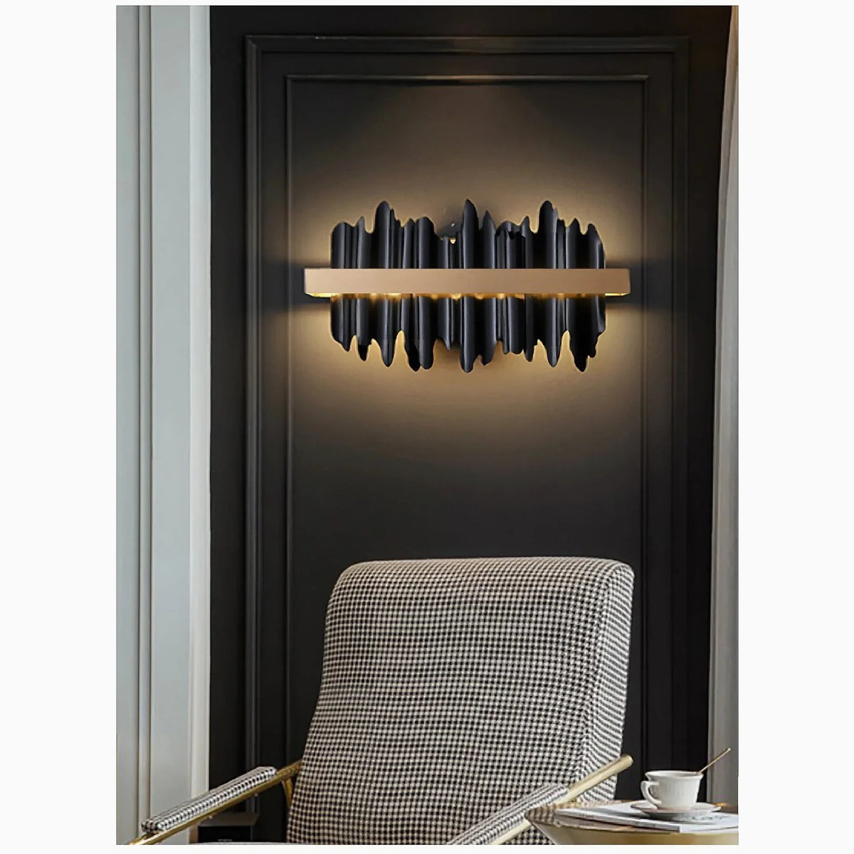 Aplique de pared LED Yondara negro y dorado – junto a un sillón