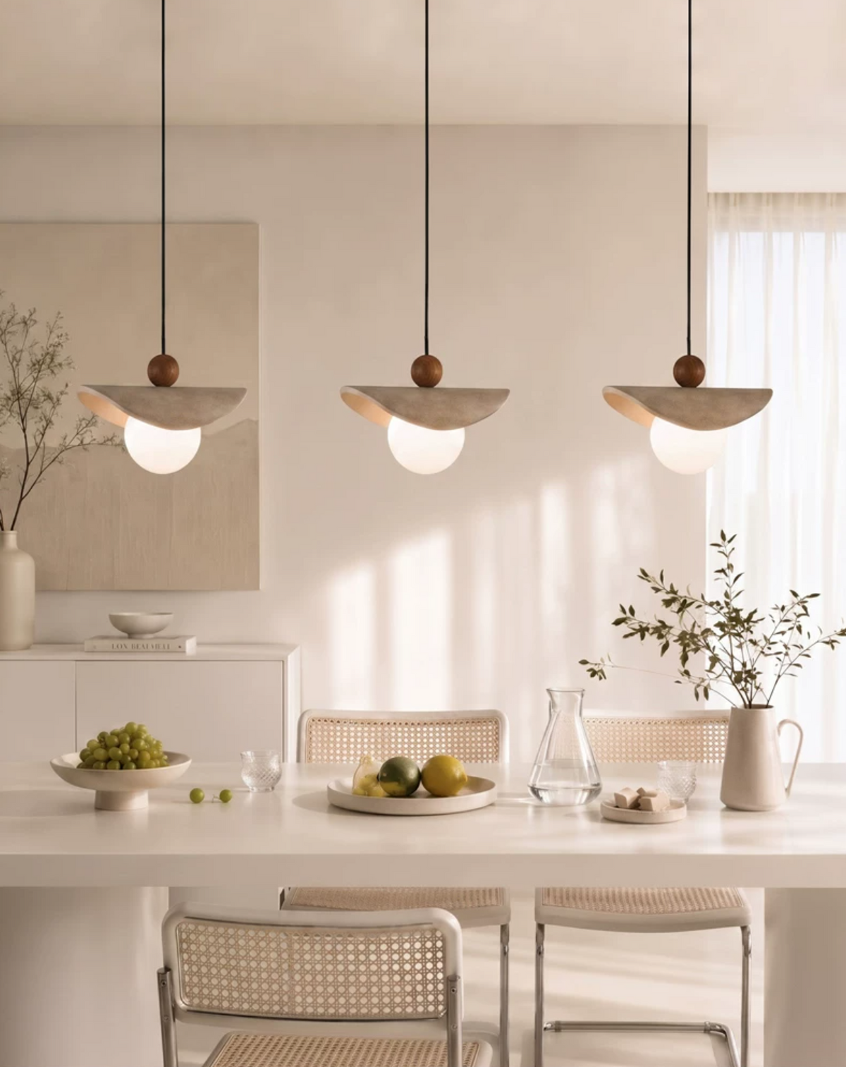 Lámpara colgante de travertino Davela – tres lámparas sobre una mesa de comedor