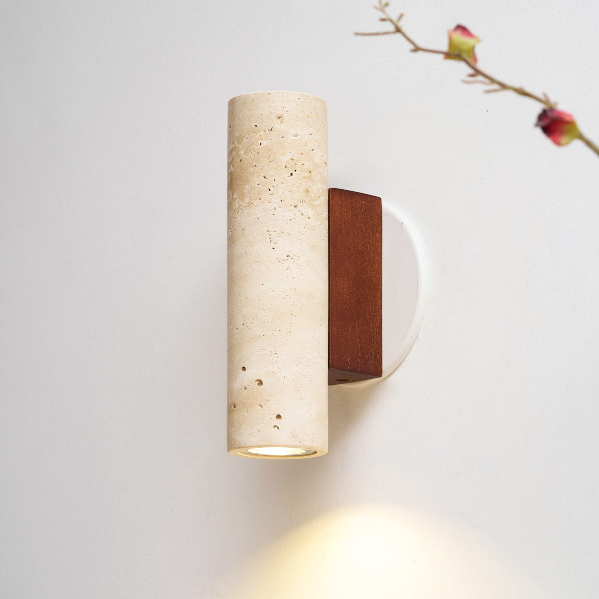 Aplique de pared de travertino Onsara – luz descendente sobre una mesa