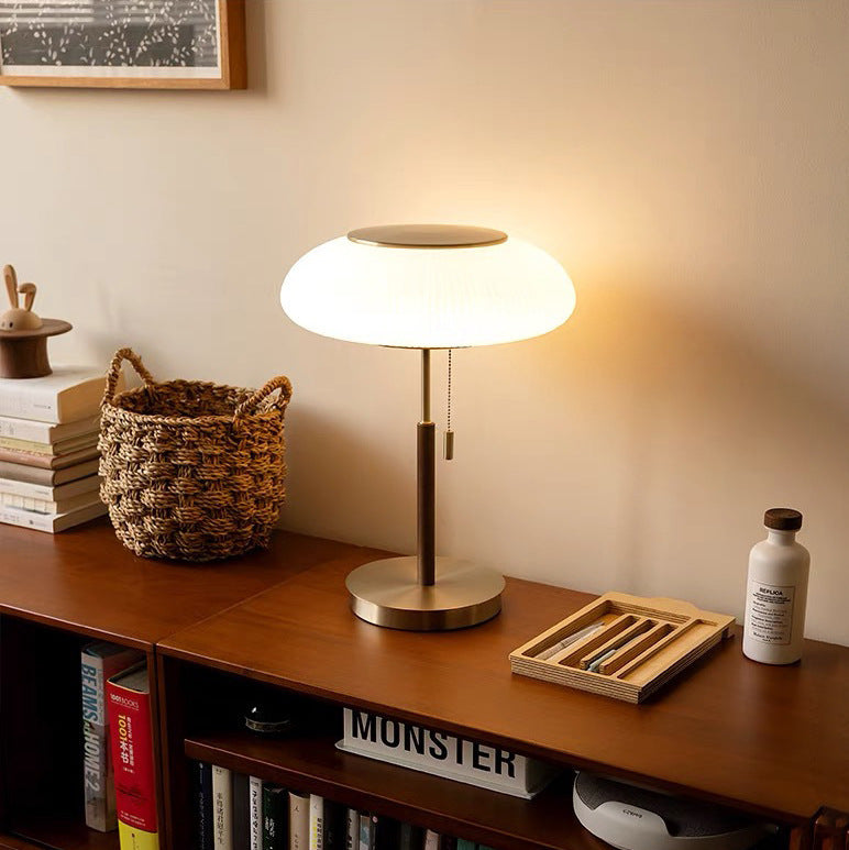 Lámpara de mesa vintage Rizala – encendida sobre una estantería baja