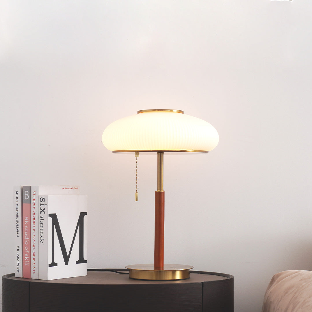 Lámpara de mesa vintage Rizala – encendida junto a unos libros