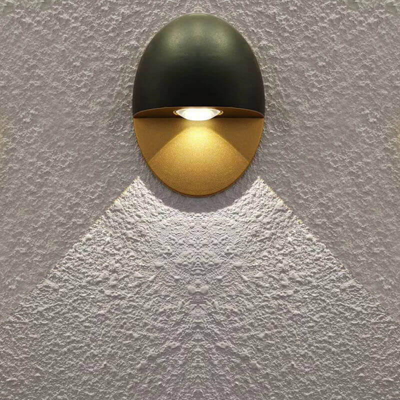 Aplique de pared exterior Yolena ovalado – negro y dorado proyectando un haz de luz