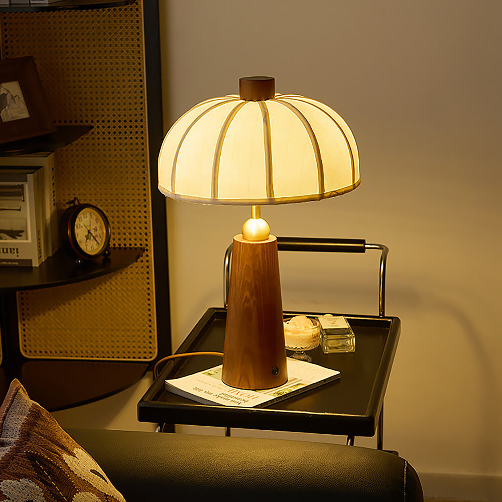 Lámpara de mesa de madera Toldina – encendida sobre una mesa auxiliar