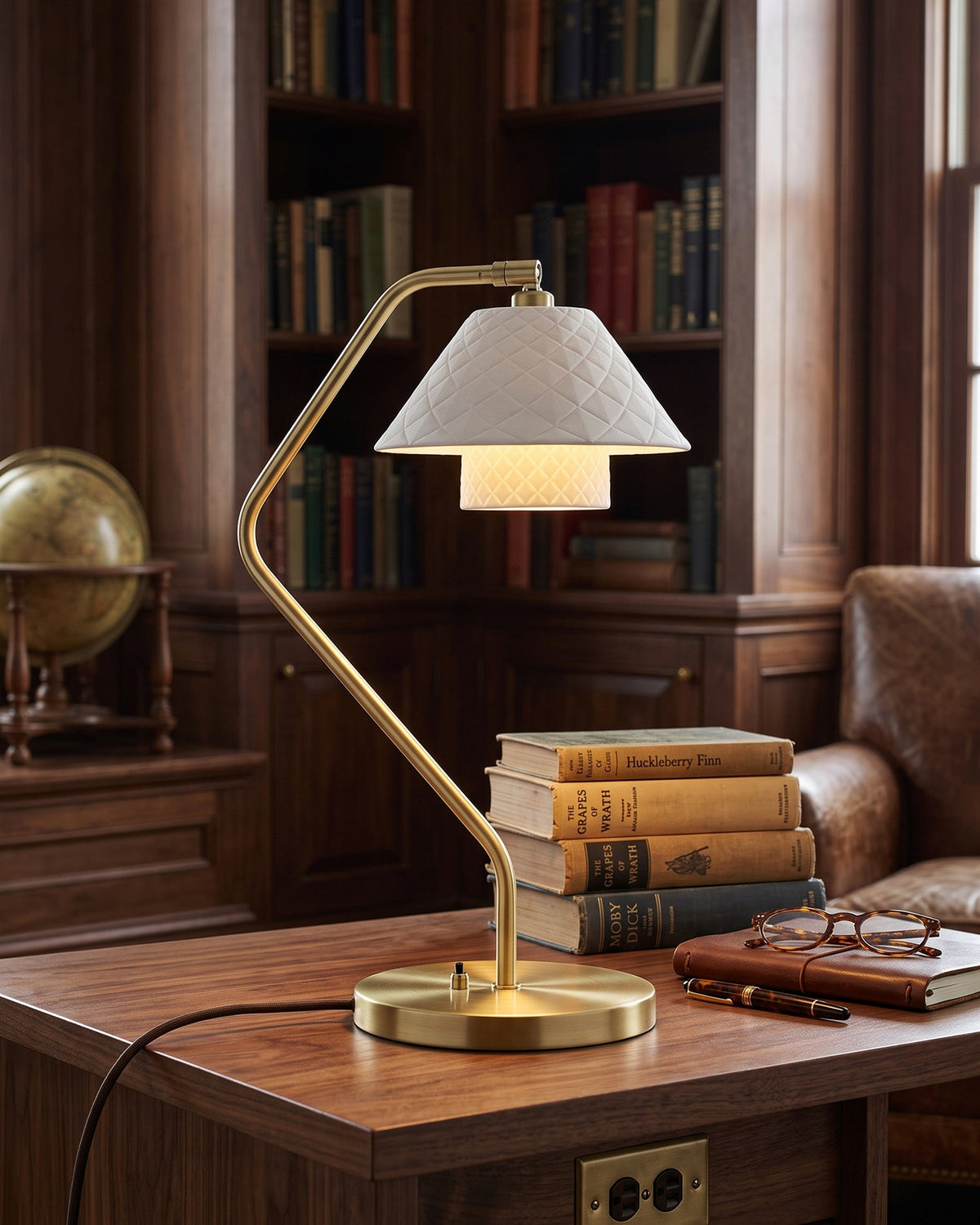 Lámpara de escritorio de latón Rombina – en una biblioteca de madera