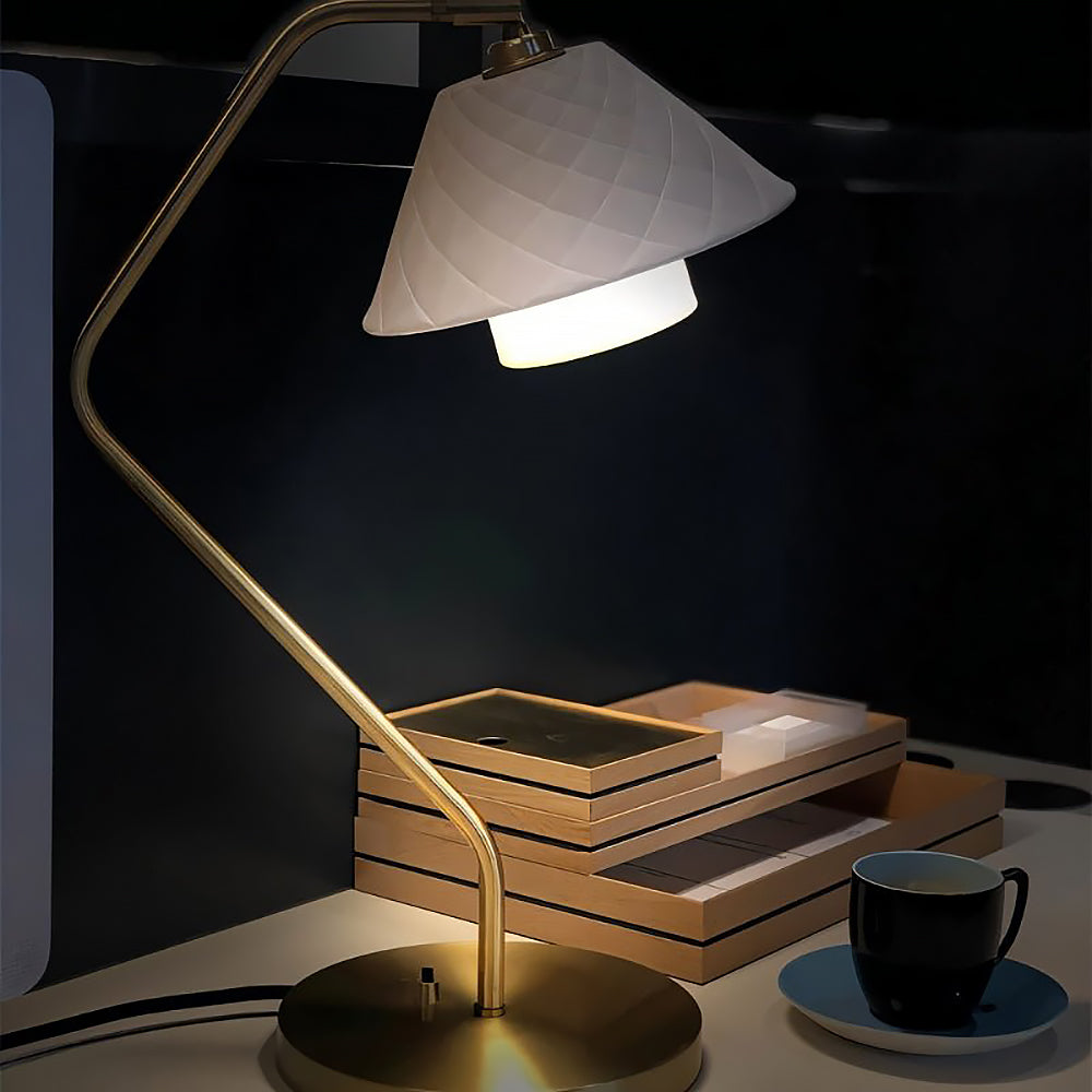 Lámpara de escritorio de latón Rombina – encendida sobre un escritorio de noche
