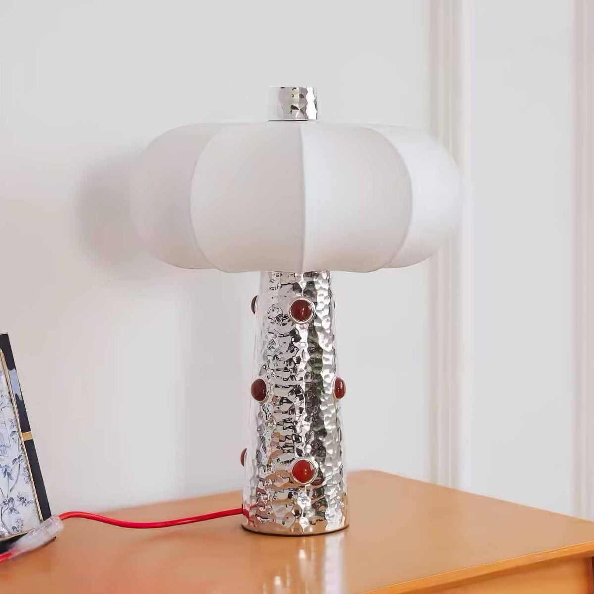 Lámpara de mesa plateada Rubela – de cerca sobre una cómoda