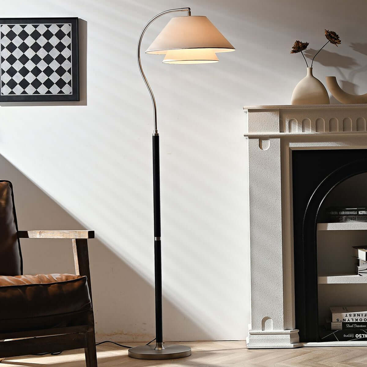 Lámpara de pie de arco Elvera – en negro junto a una chimenea