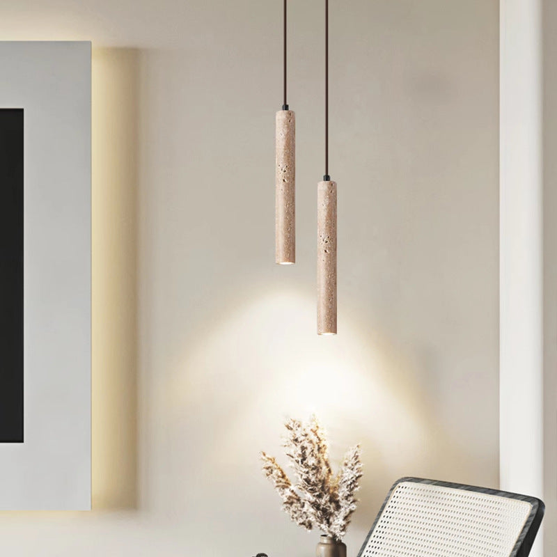 Lámpara colgante de travertino Cañalita – doble con dos tubos junto a un sillón