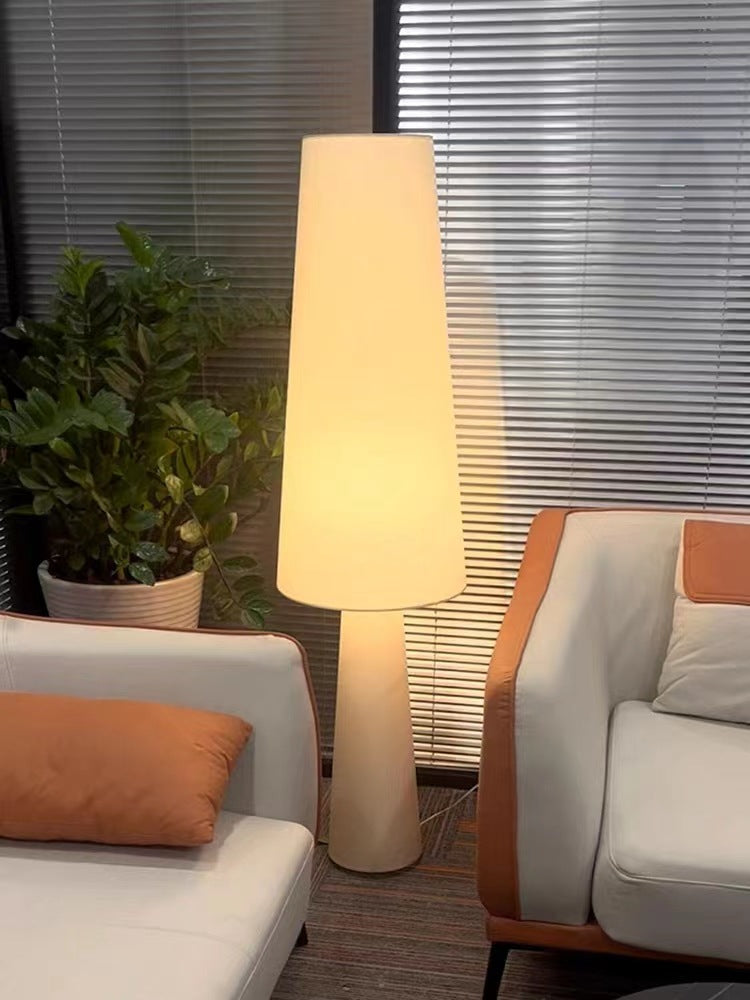 Lámpara de pie wabi sabi Ustela con pantalla de tela – encendida junto a un sofá