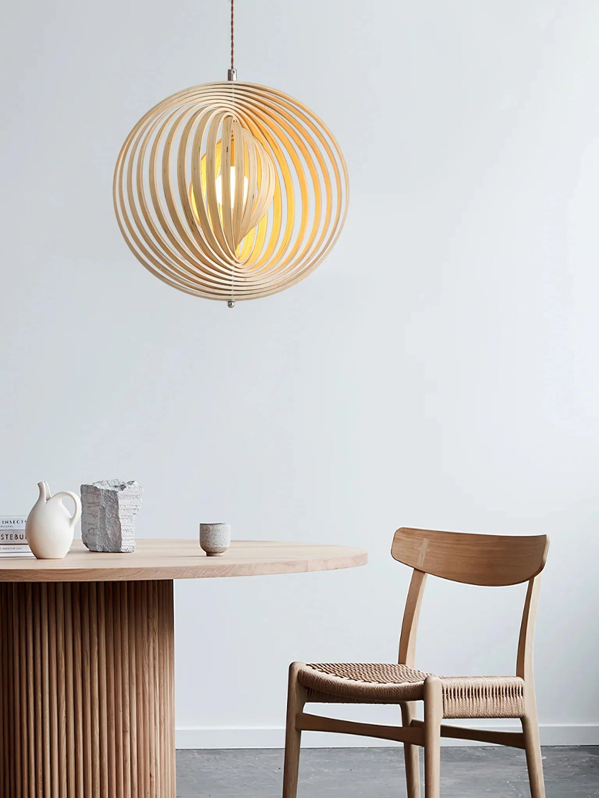 Lámpara colgante esfera de láminas de madera Aluma sobre una mesa de comedor – imagen 3