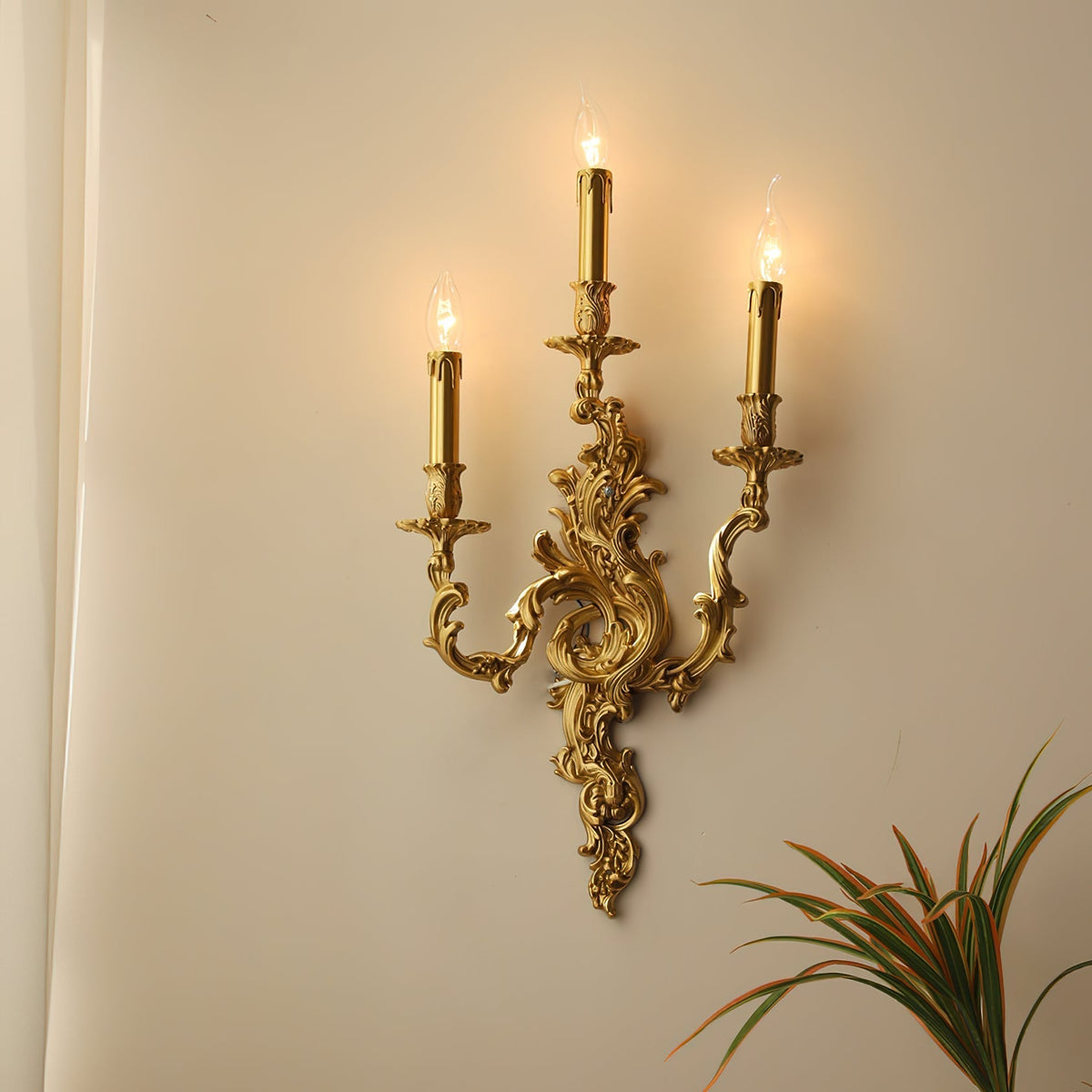 Aplique de pared rococó de latón Ledora – 3 luces encendido sobre pared cálida