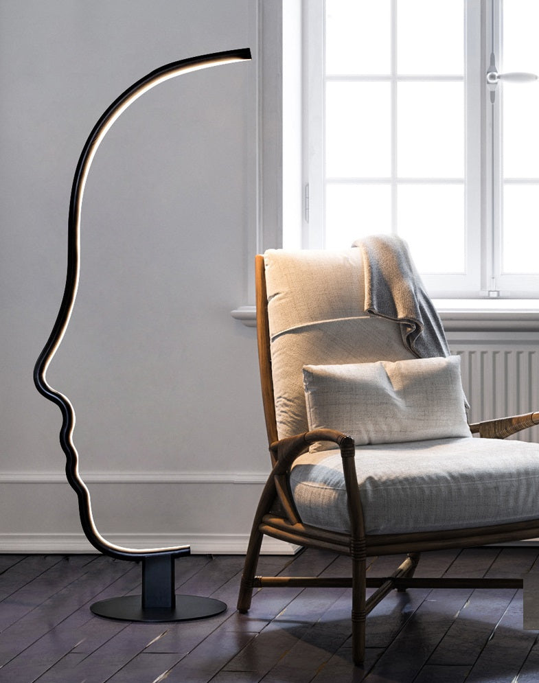 Lámpara de pie LED con silueta de rostro Quiara – junto a un sillón