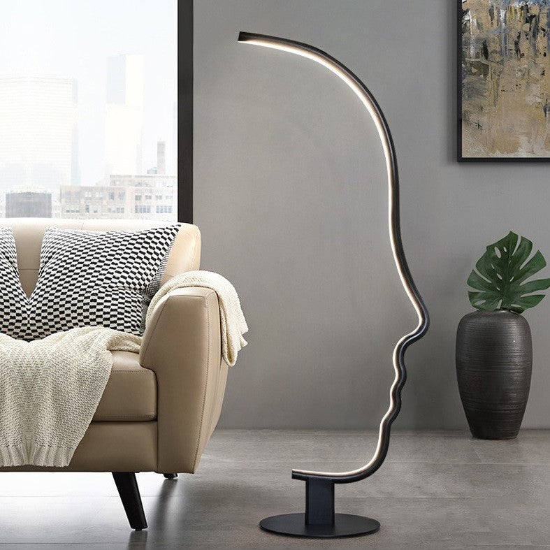 Lámpara de pie LED con silueta de rostro Quiara – junto a un sofá claro