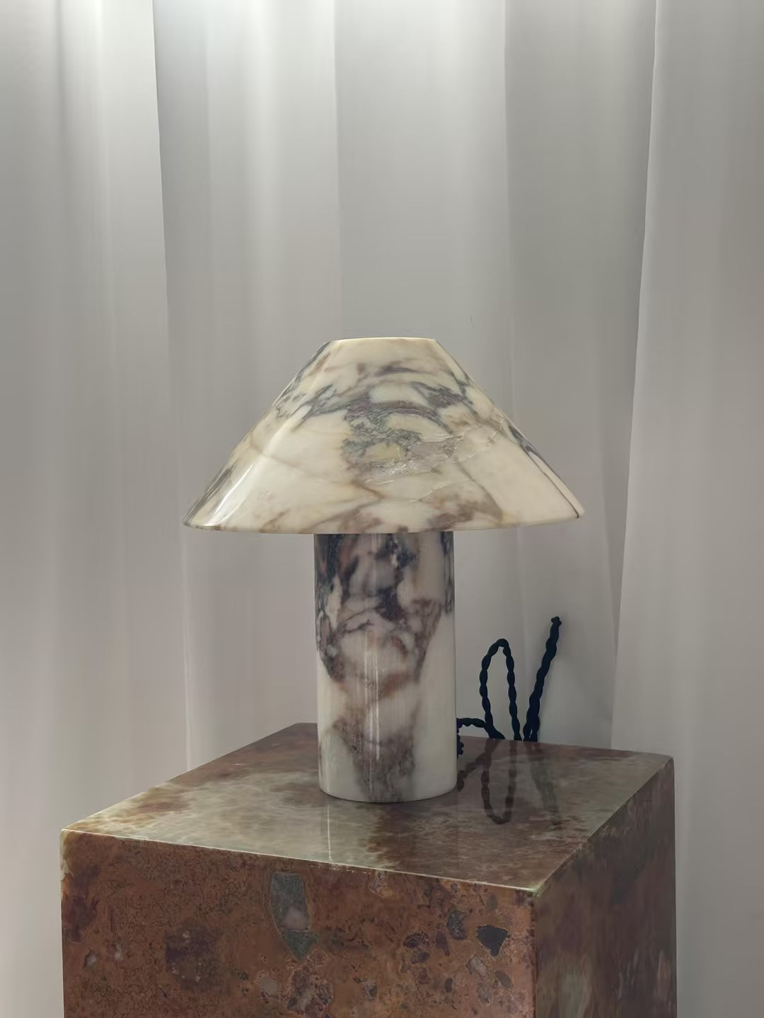 Lámpara de mesa de mármol Setona – vista frontal sobre un pedestal