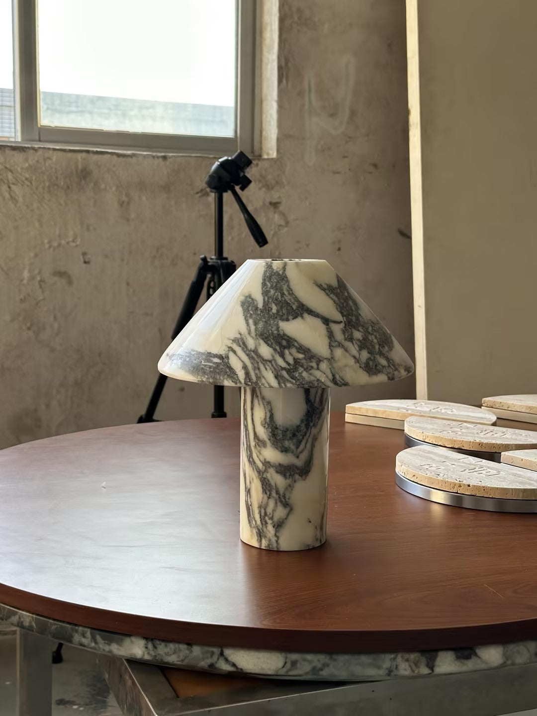 Lámpara de mesa de mármol Setona – sobre una mesa redonda junto a la ventana