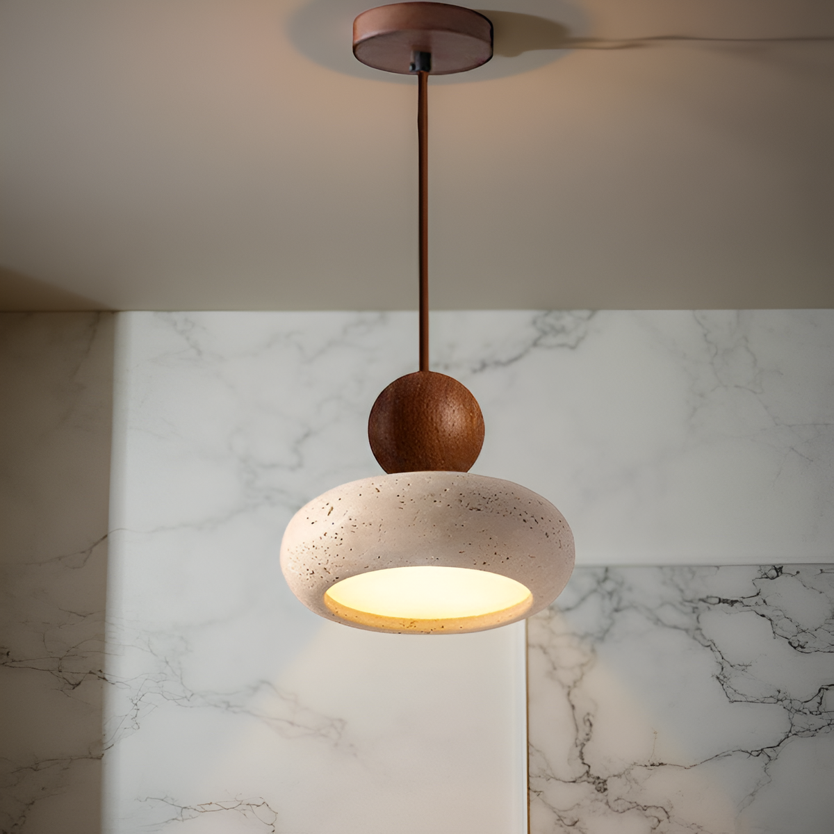 Lámpara colgante de travertino Donela – junto a una pared de mármol