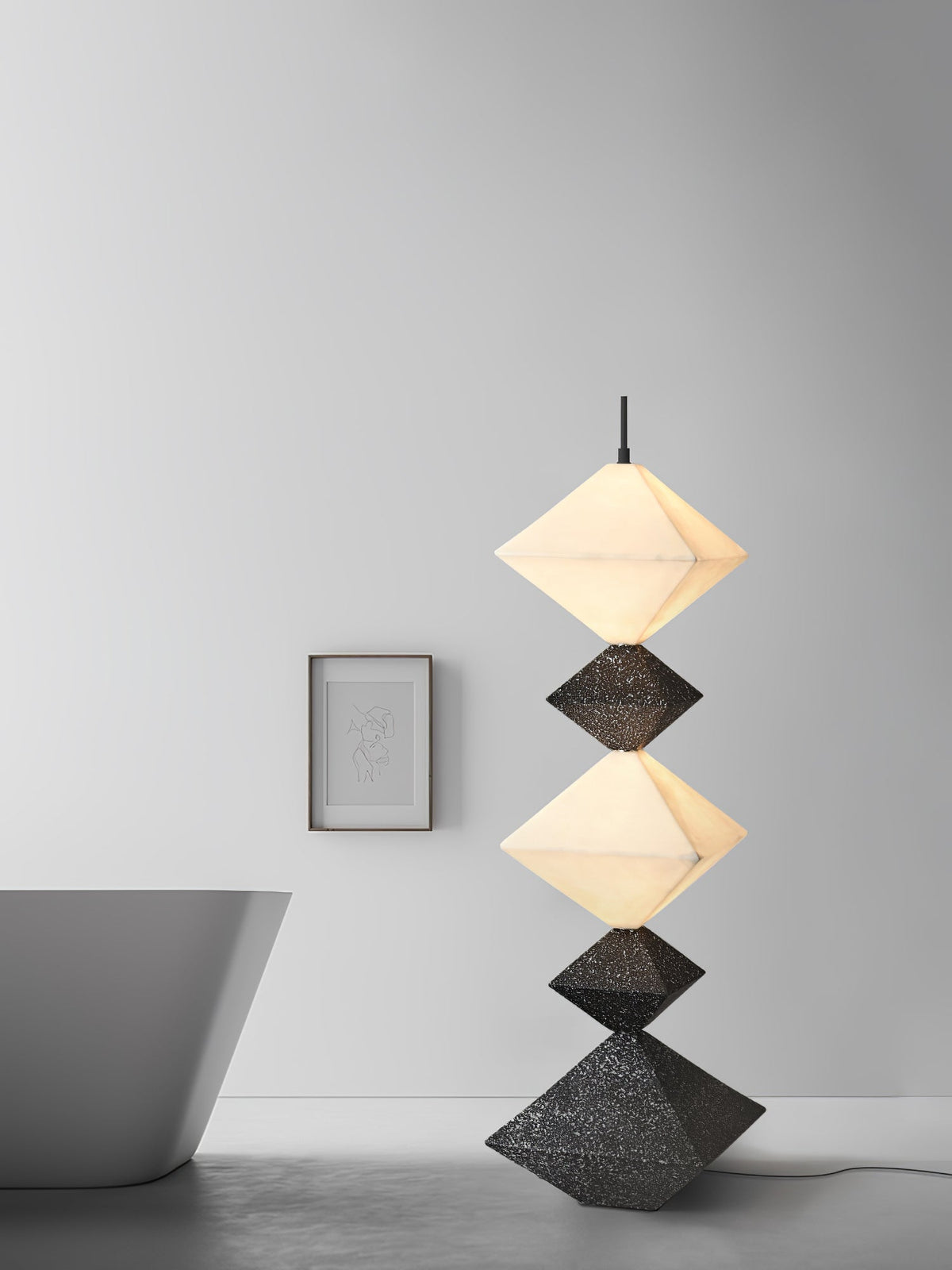 Lámpara de pie LED con rombos apilados Peluma – en negro y blanco en una estancia con bañera
