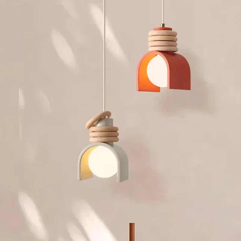 Lámpara colgante de resina Arcolina – en blanco y naranja junto a una pared