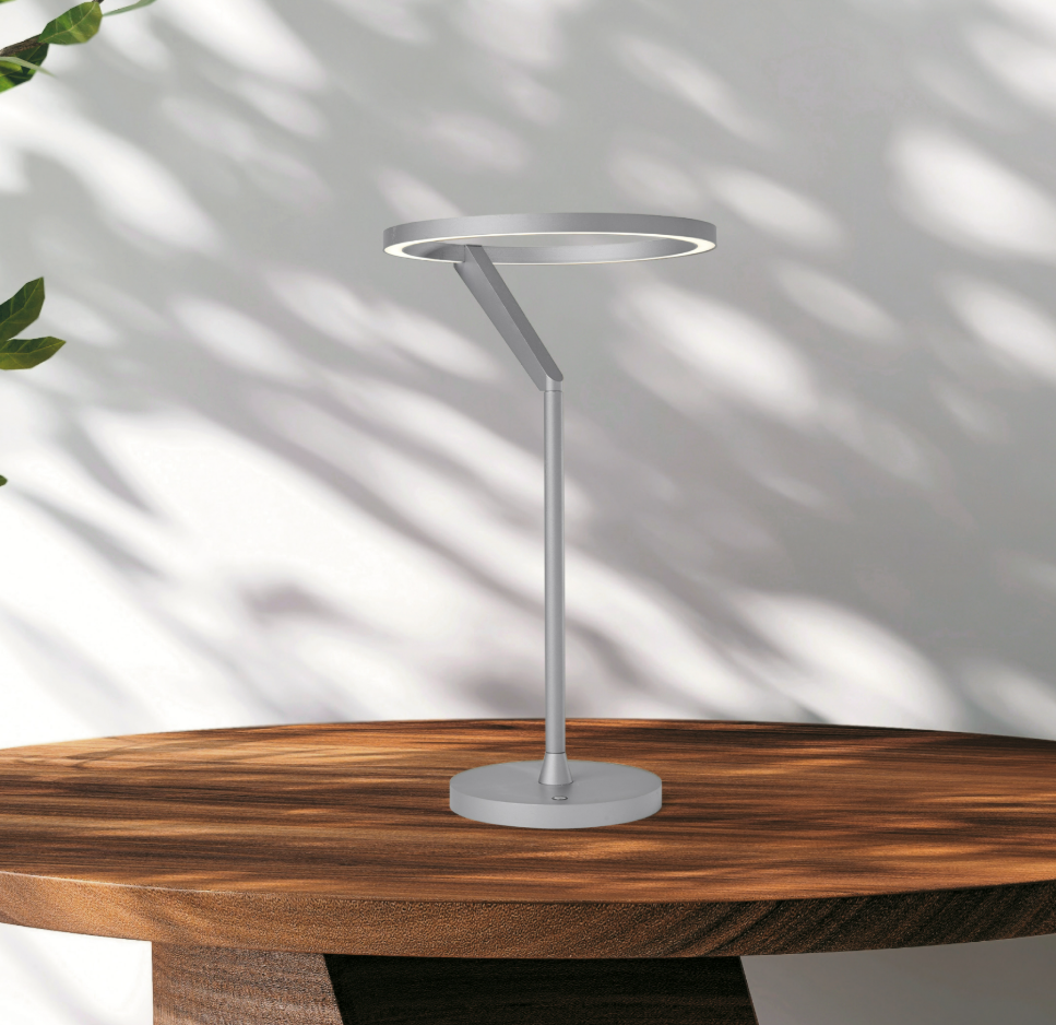 Lámpara de mesa LED con aro de luz Orlena – en titanio sobre una mesa de madera