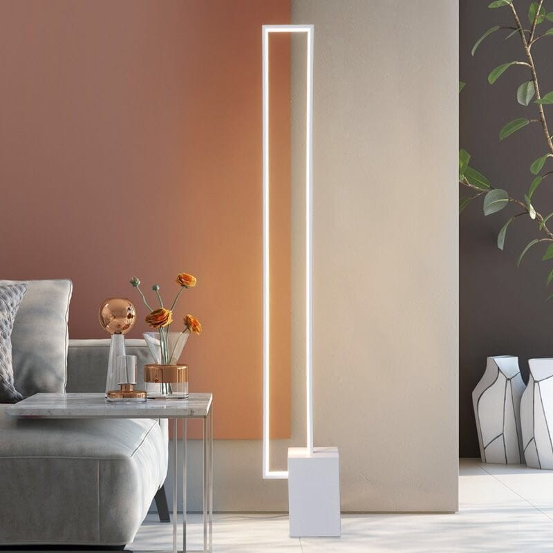 Lámpara de pie LED rectangular Tevaro – en blanco junto a un sofá