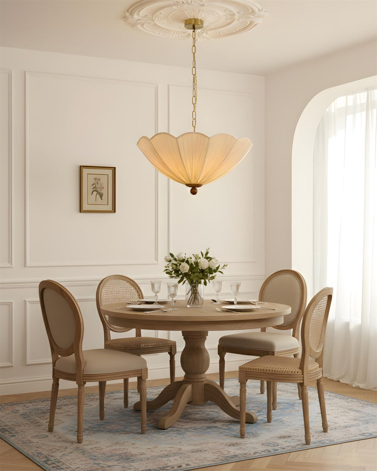 Lámpara colgante de tela plisada Conchela – sobre una mesa de comedor con sillas de medallón