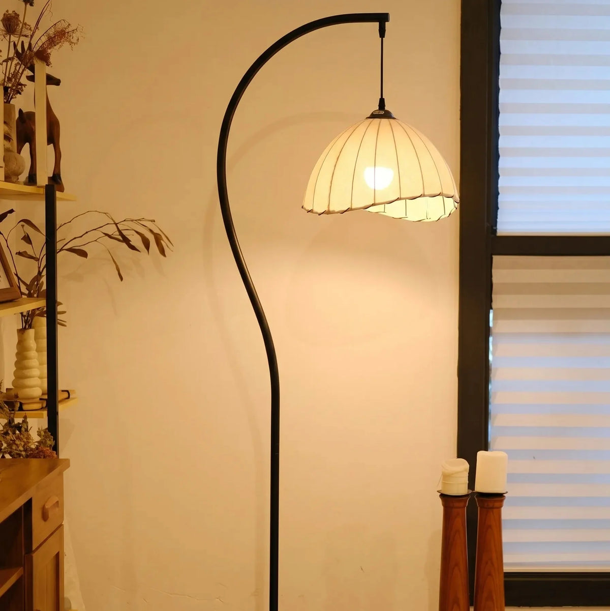Lámpara de pie de arco Hilacia – encendida junto a la ventana