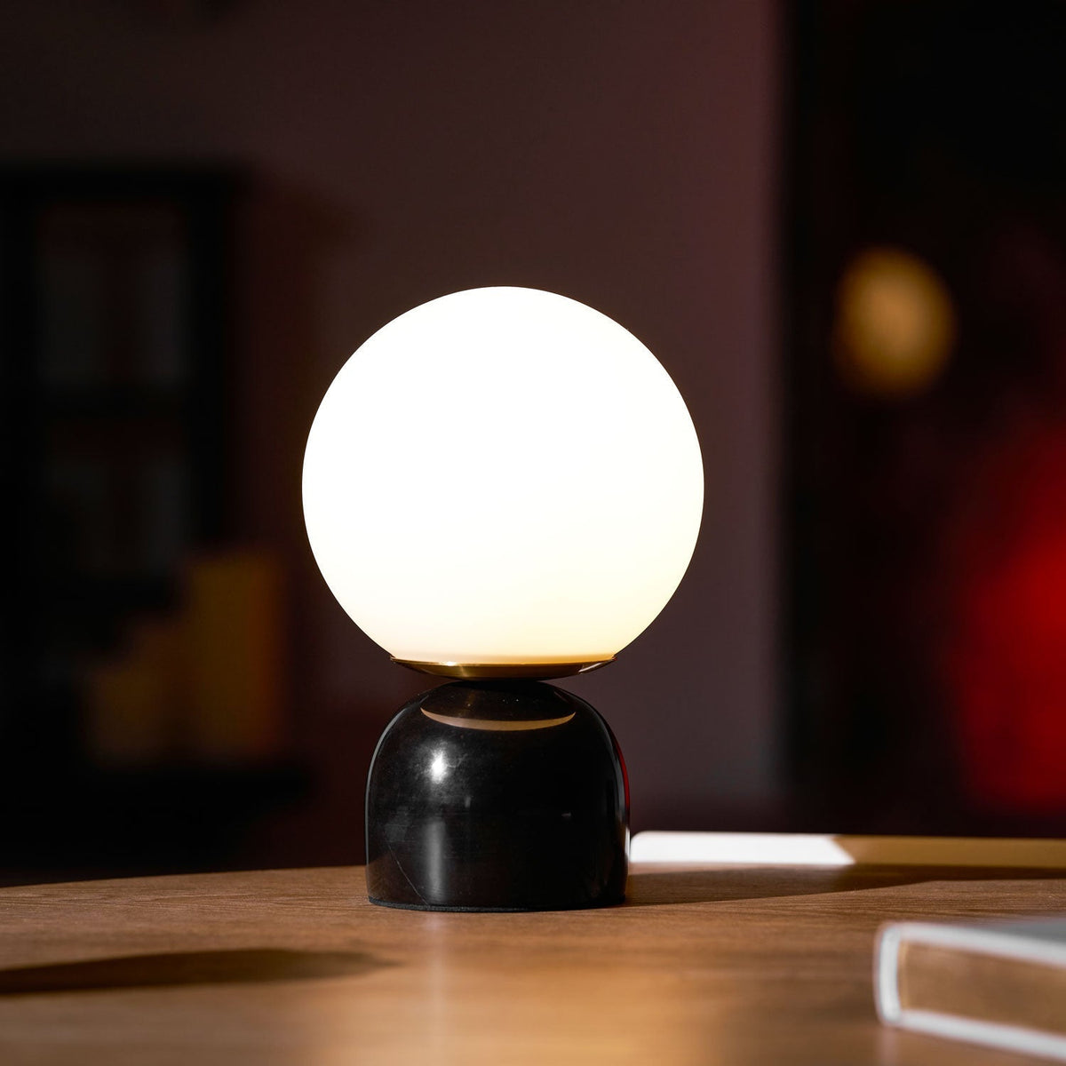 Lámpara de mesita Dunela con globo opal y base de mármol sobre una mesa de madera – imagen 25