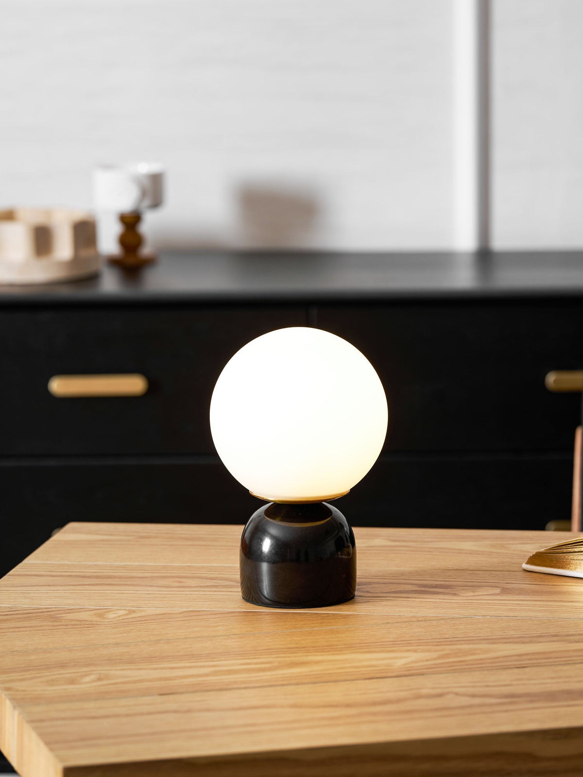 Lámpara de mesita Dunela con globo opal y base de mármol sobre una mesa de madera – imagen 20