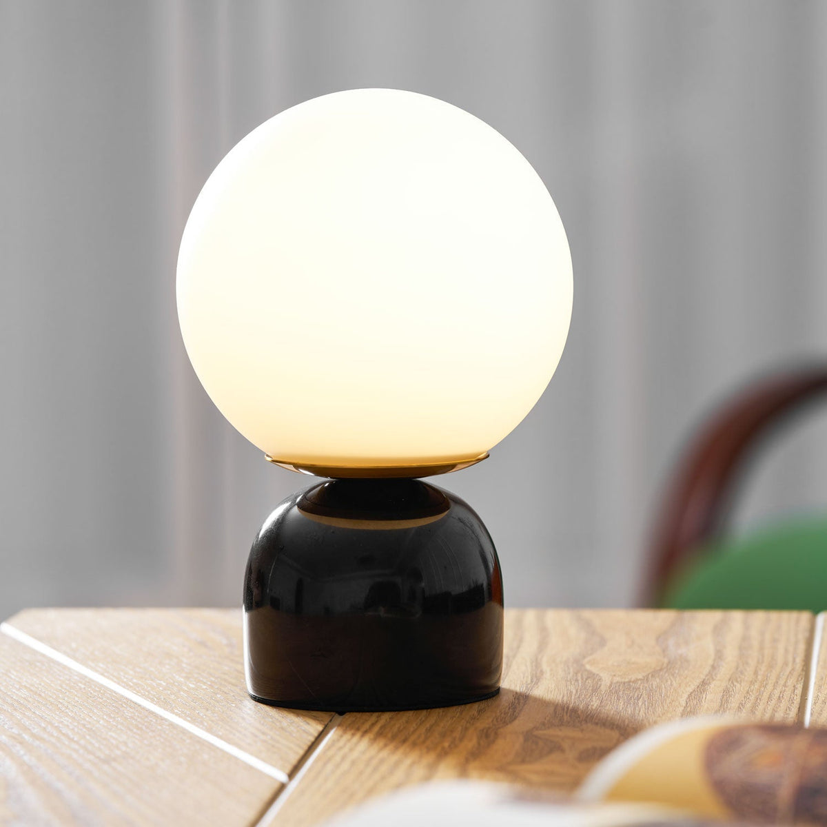 Lámpara de mesita Dunela con globo opal y base de mármol sobre una mesa de madera – imagen 21