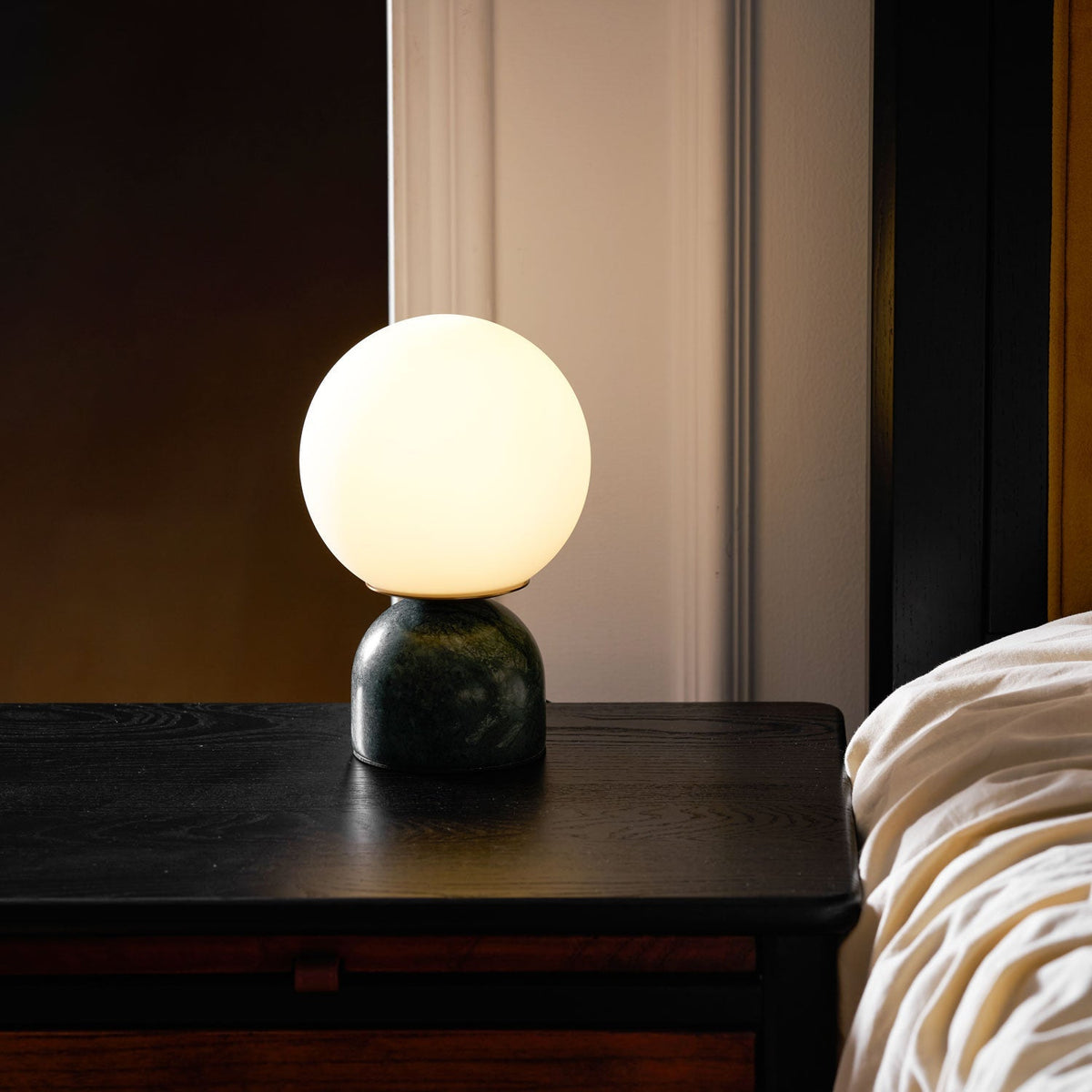 Lámpara de mesita Dunela con globo opal y base de mármol sobre una mesa de madera – imagen 16