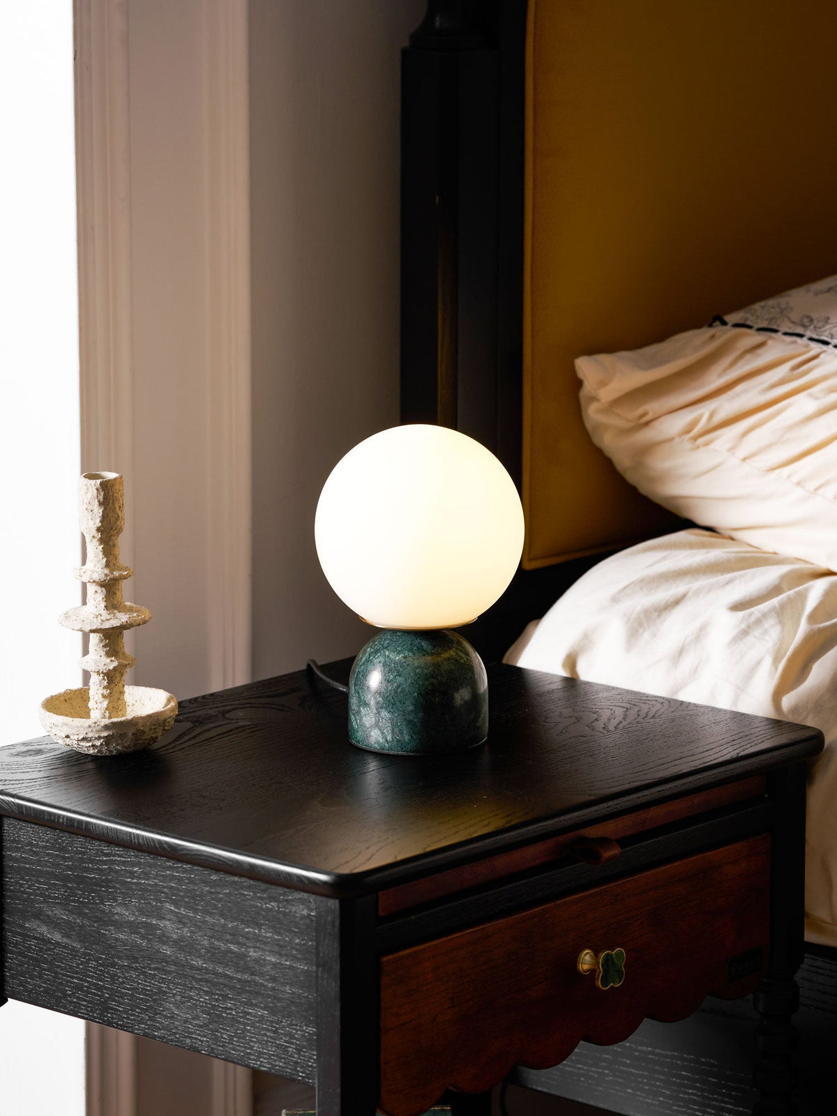 Lámpara de mesita Dunela con globo opal y base de mármol sobre una mesa de madera – imagen 17