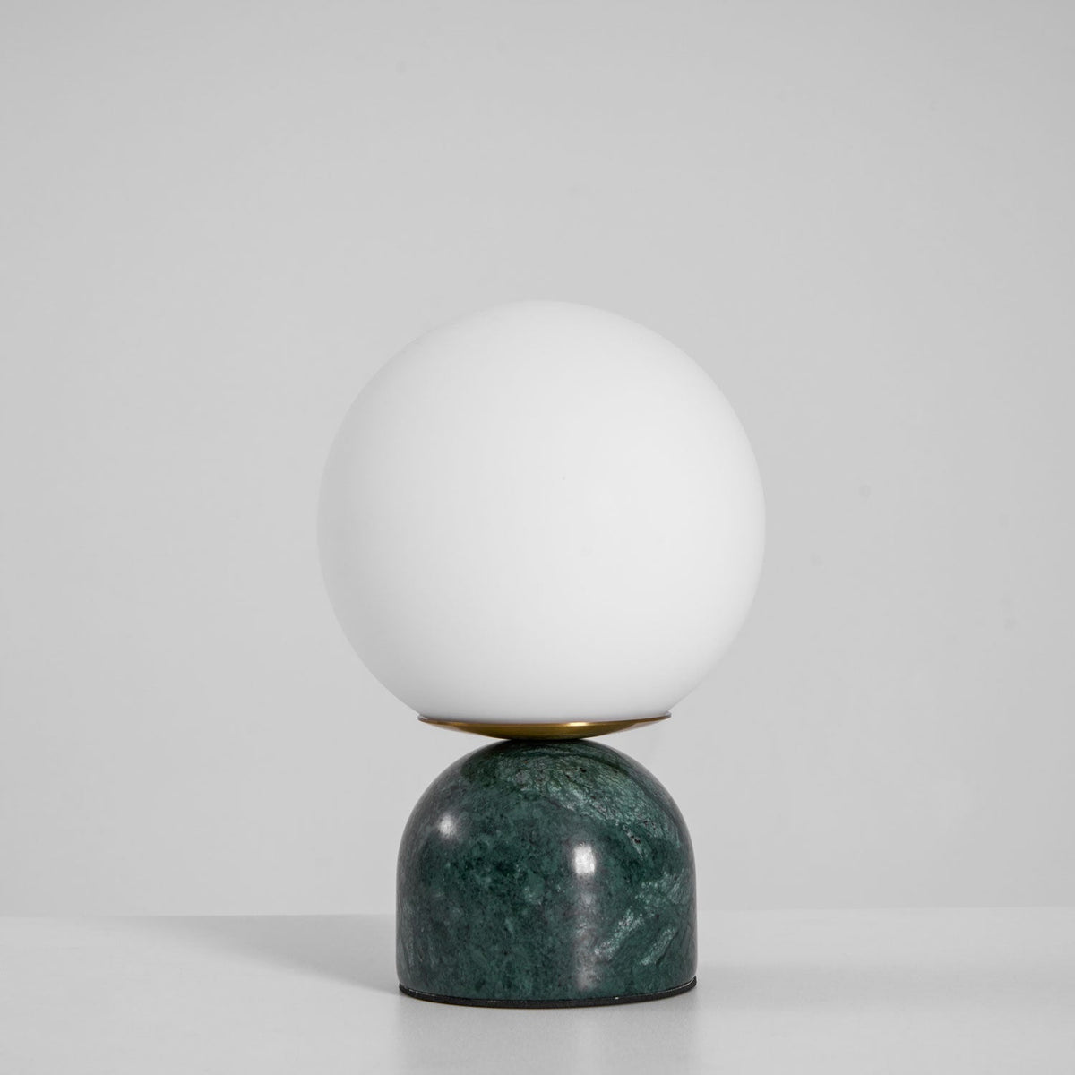 Lámpara de mesita Dunela con globo opal y base de mármol sobre una mesa de madera – imagen 18