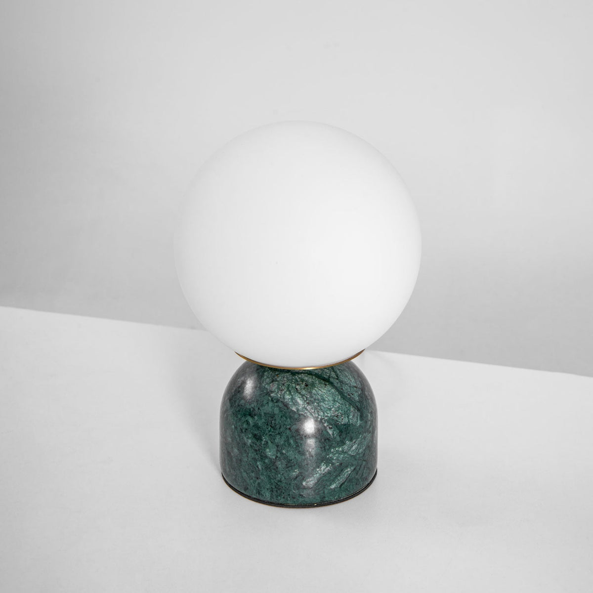 Lámpara de mesita Dunela con globo opal y base de mármol sobre una mesa de madera – imagen 11
