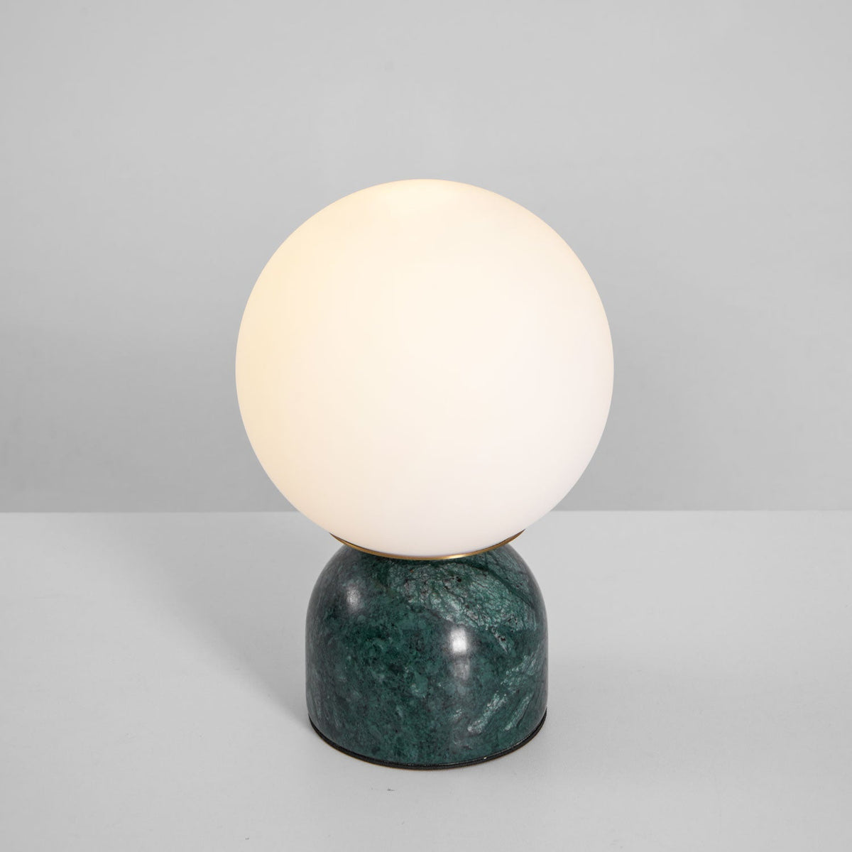 Lámpara de mesita Dunela con globo opal y base de mármol sobre una mesa de madera – imagen 12