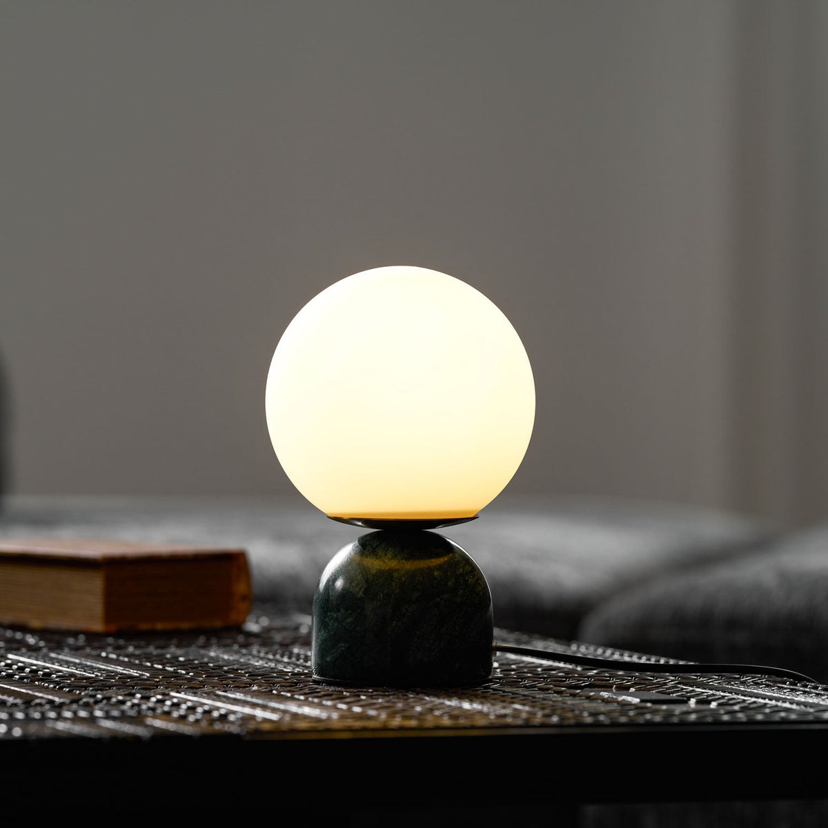 Lámpara de mesita Dunela con globo opal y base de mármol sobre una mesa de madera – imagen 13
